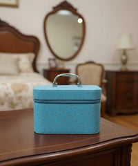 Blue speckled makeup case on a wooden dresser in a bedroom setting
