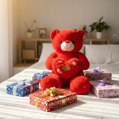 Red teddy bear with a heart and small gift boxes on a bed