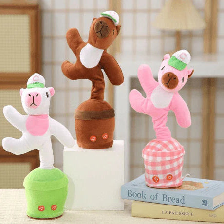 Three plush toys resembling animals on books with a blurred background